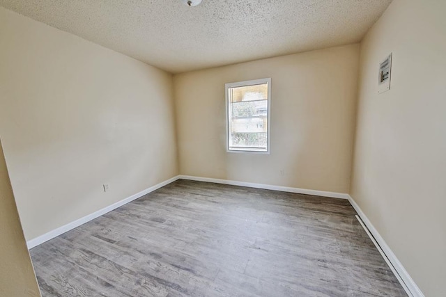 empty room featuring light hardwood / wood-style floors and a textured ceiling