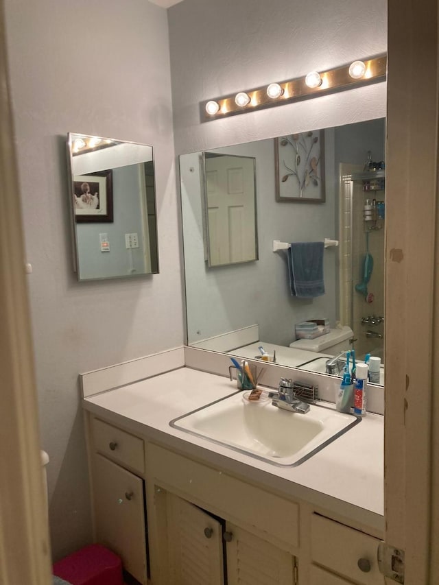 bathroom with toilet and vanity with extensive cabinet space