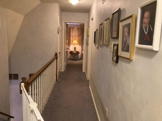 hall with dark colored carpet