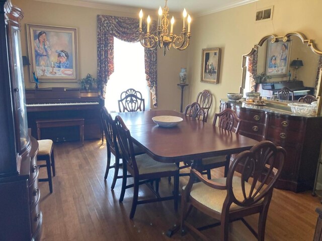 dining area featuring a chandelier, ornamental molding, and dark wood-type flooring