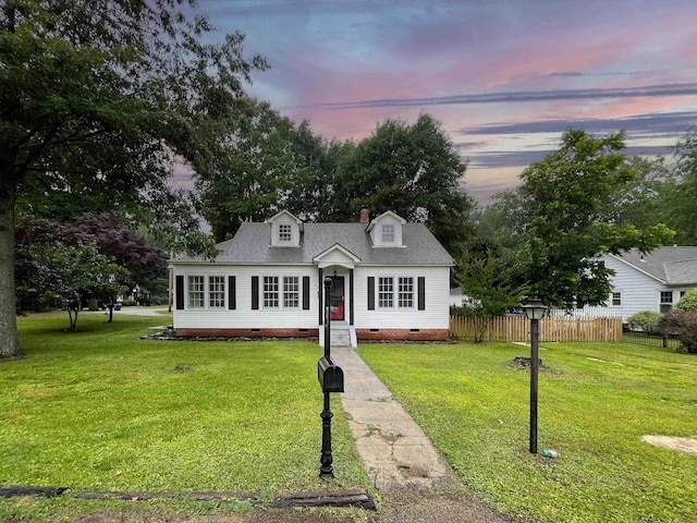 cape cod-style house with a lawn