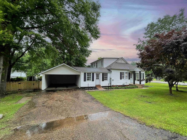 view of front of home with covered porch, a carport, and a lawn