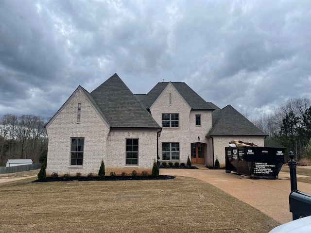 french country inspired facade with a front lawn