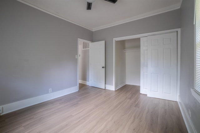 unfurnished bedroom with ceiling fan, light hardwood / wood-style flooring, ornamental molding, and a closet