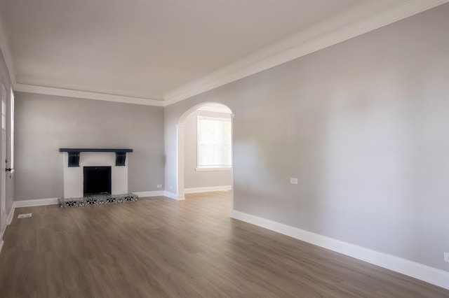 unfurnished living room featuring ornamental molding and dark hardwood / wood-style floors