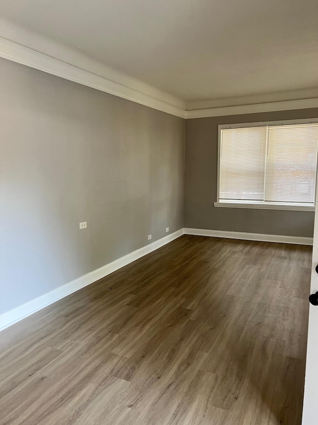 empty room with ornamental molding and hardwood / wood-style flooring