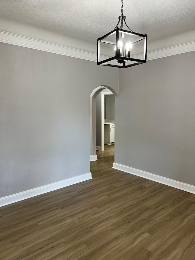 spare room featuring dark hardwood / wood-style flooring and a textured ceiling