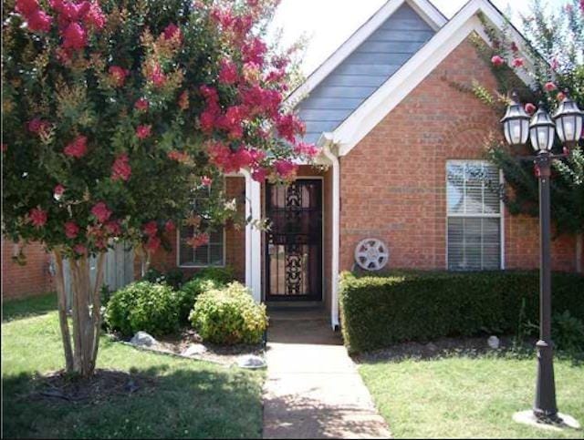 view of exterior entry with a lawn