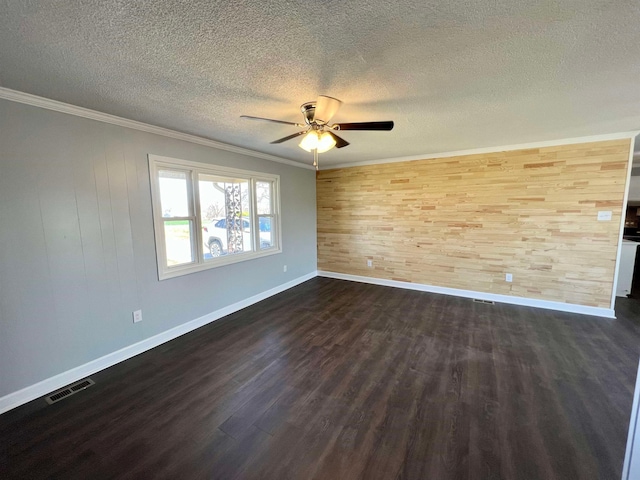 spare room featuring dark hardwood / wood-style flooring, ceiling fan, ornamental molding, and wooden walls