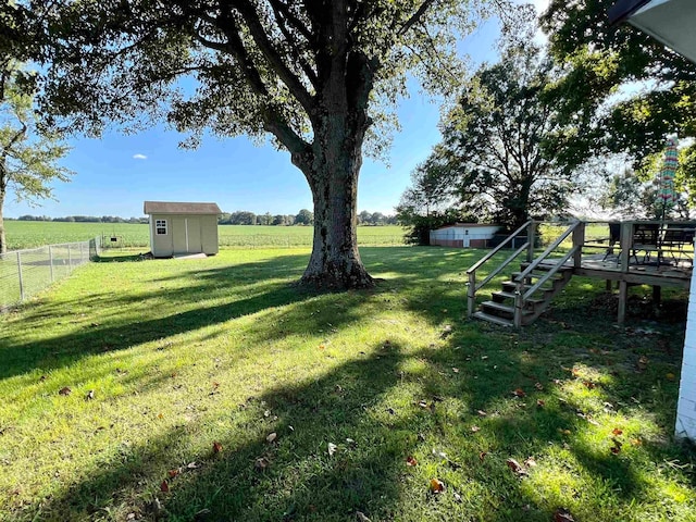 view of yard with a rural view and a storage shed