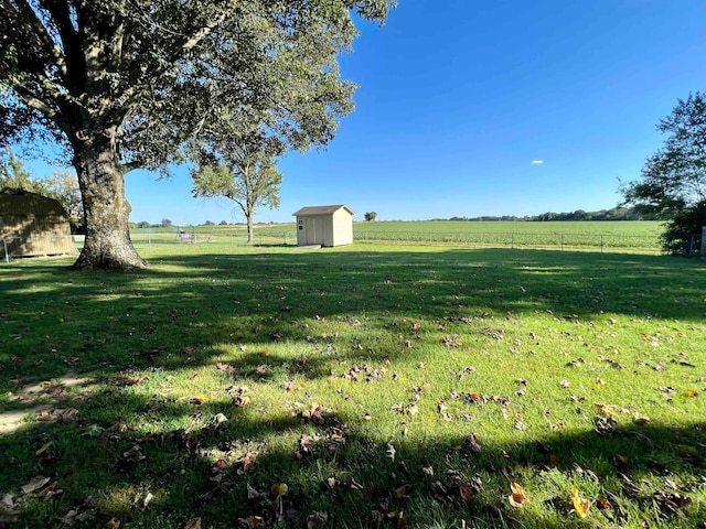 view of yard with a rural view and a shed