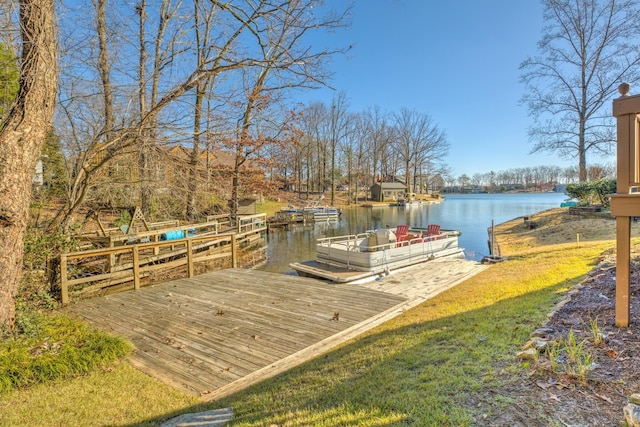 view of dock with a water view and a yard