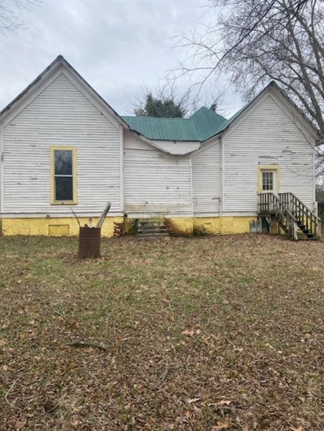 rear view of house featuring a lawn