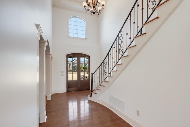 foyer featuring an inviting chandelier, dark wood-type flooring, and a high ceiling