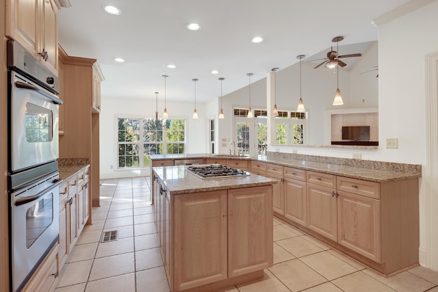 1615 Cedar Lake Cir, Hernando, MS 38632 - kitchen with kitchen peninsula, light stone countertops, ceiling fan with notable chandelier, appliances with stainless steel finishes, and light tile floors