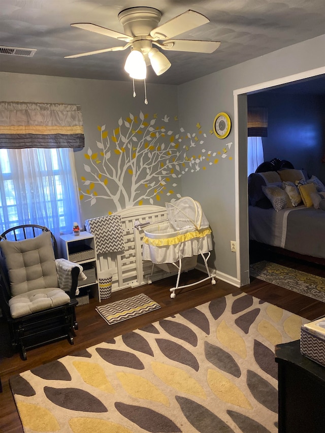 bedroom with dark hardwood / wood-style flooring and ceiling fan