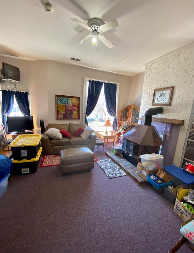 living room with ceiling fan, carpet flooring, and brick wall