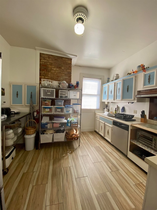 kitchen featuring light wood-type flooring, brick wall, sink, and dishwasher