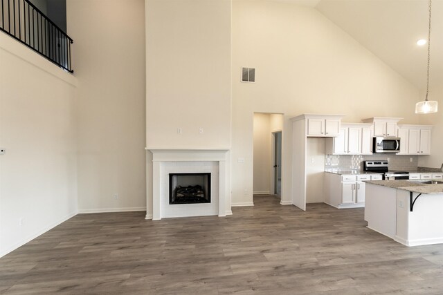 kitchen featuring stainless steel appliances, white cabinetry, a breakfast bar, and light hardwood / wood-style floors