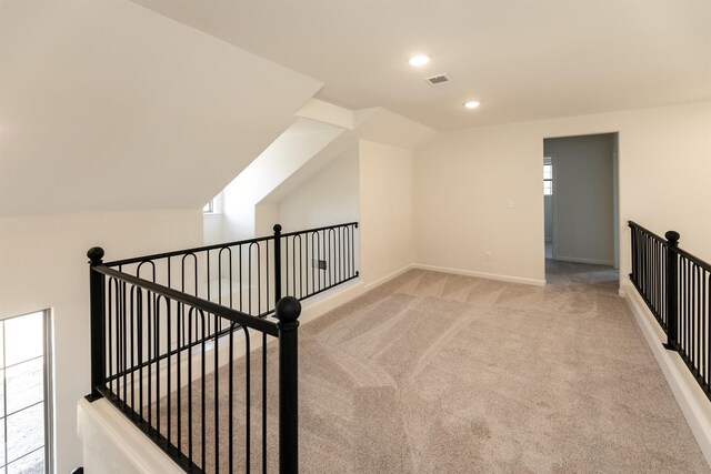 additional living space featuring lofted ceiling and light carpet