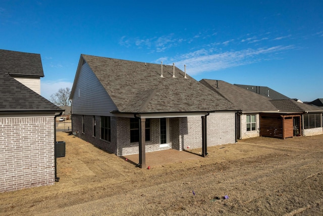 rear view of house with a lawn and a patio