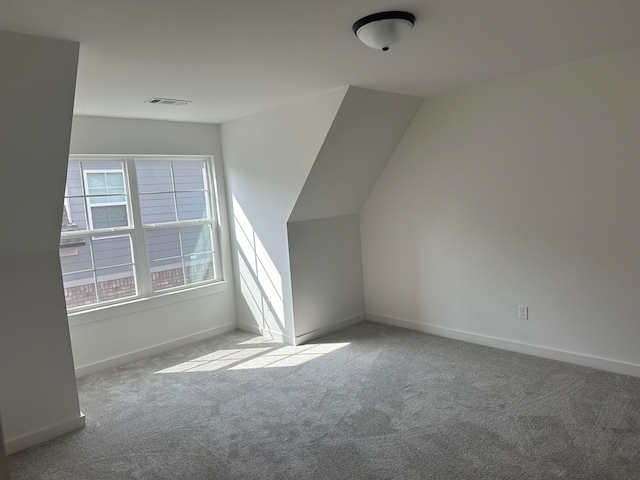 bonus room featuring vaulted ceiling and light colored carpet