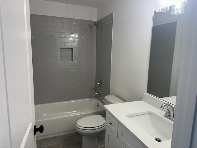 full bathroom featuring wood-type flooring, vanity, toilet, and tiled shower / bath combo