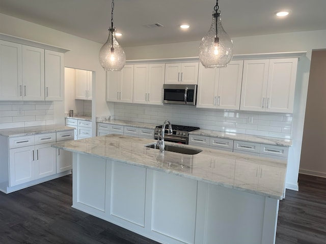 kitchen with white cabinetry, stainless steel appliances, and decorative light fixtures