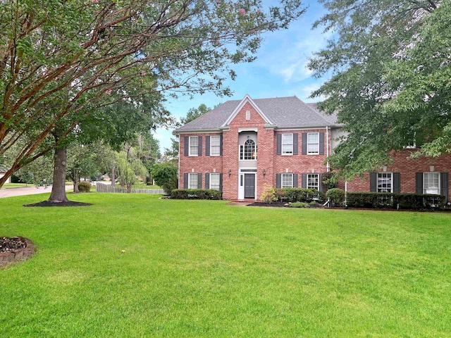 colonial-style house featuring a front lawn