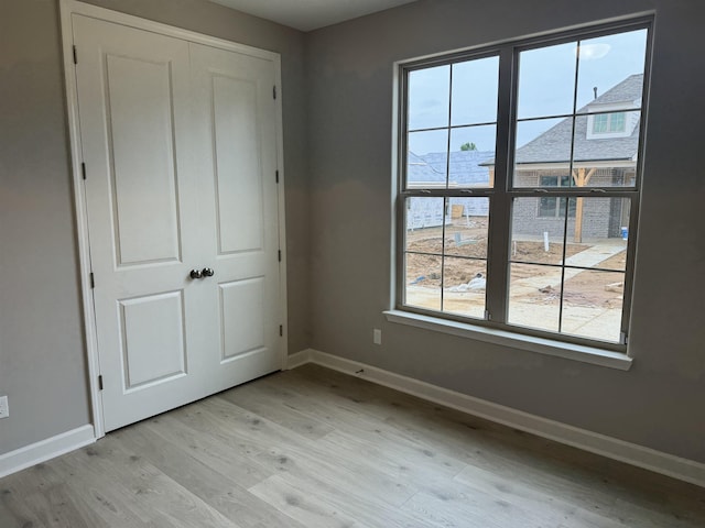 unfurnished bedroom featuring light hardwood / wood-style floors and a closet