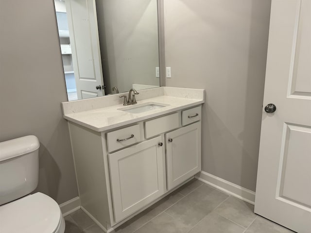 bathroom with tile patterned flooring, vanity, and toilet