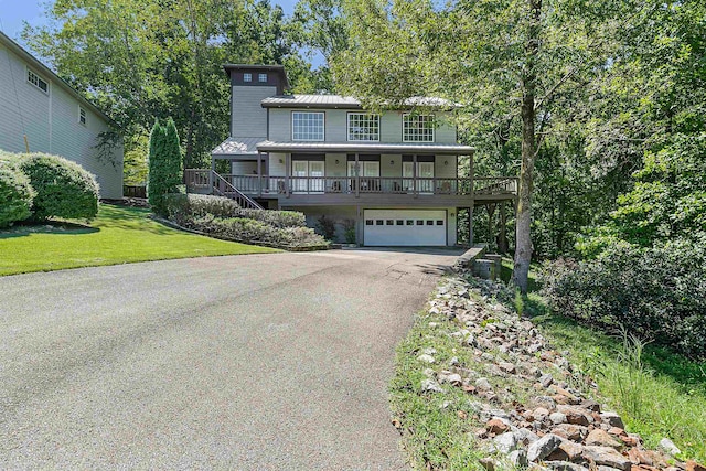 view of front property featuring a front lawn, a porch, and a garage