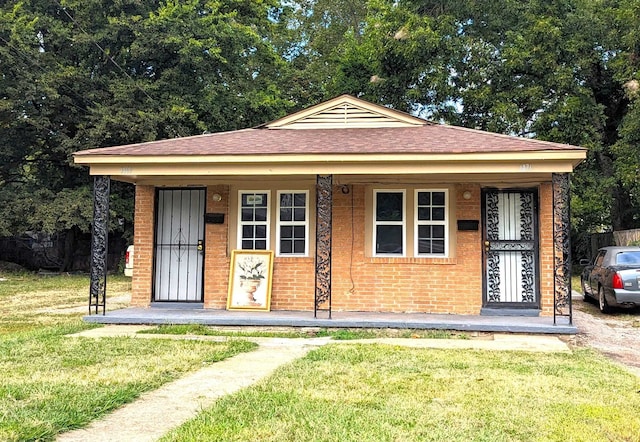 bungalow-style house with a porch and a front lawn