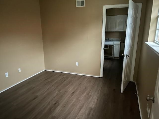 unfurnished bedroom with dark hardwood / wood-style floors