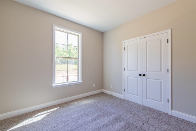 unfurnished bedroom featuring a closet and light colored carpet