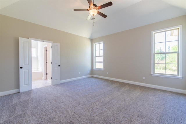 spare room featuring light carpet, lofted ceiling, and ceiling fan