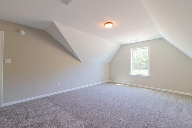 bonus room with light colored carpet and lofted ceiling