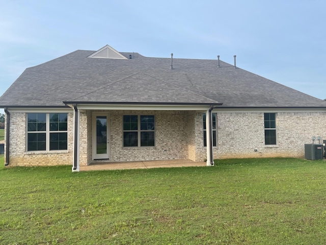 rear view of house featuring a yard, central air condition unit, and a patio area