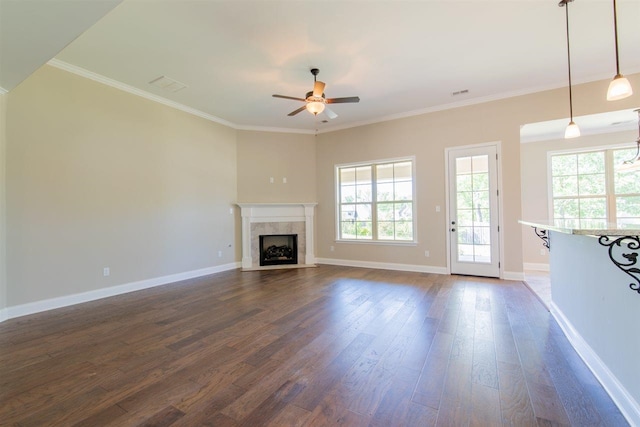 unfurnished living room with ceiling fan, dark wood-type flooring, and a healthy amount of sunlight