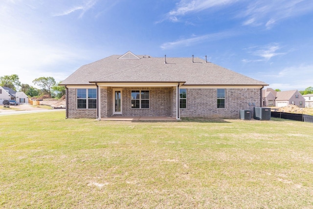 rear view of property with a yard, a patio area, and central AC unit