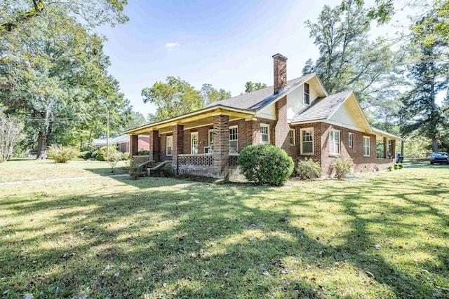 rear view of property with a yard and a porch