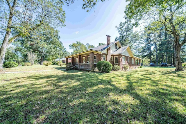 rear view of property featuring a porch and a yard