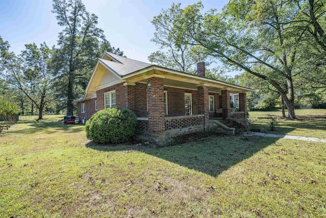 view of side of property with a yard and a porch