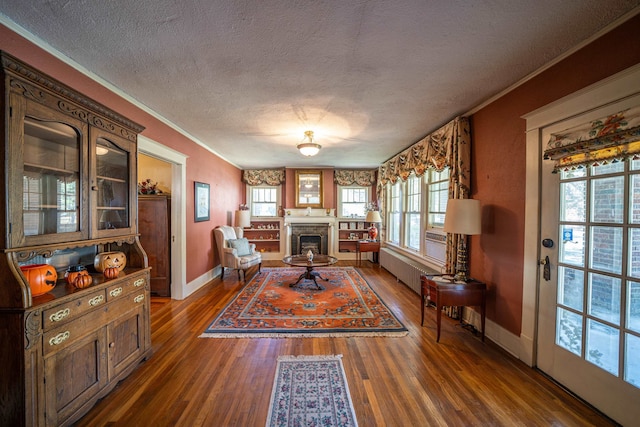 interior space with dark hardwood / wood-style flooring, crown molding, radiator, and a textured ceiling