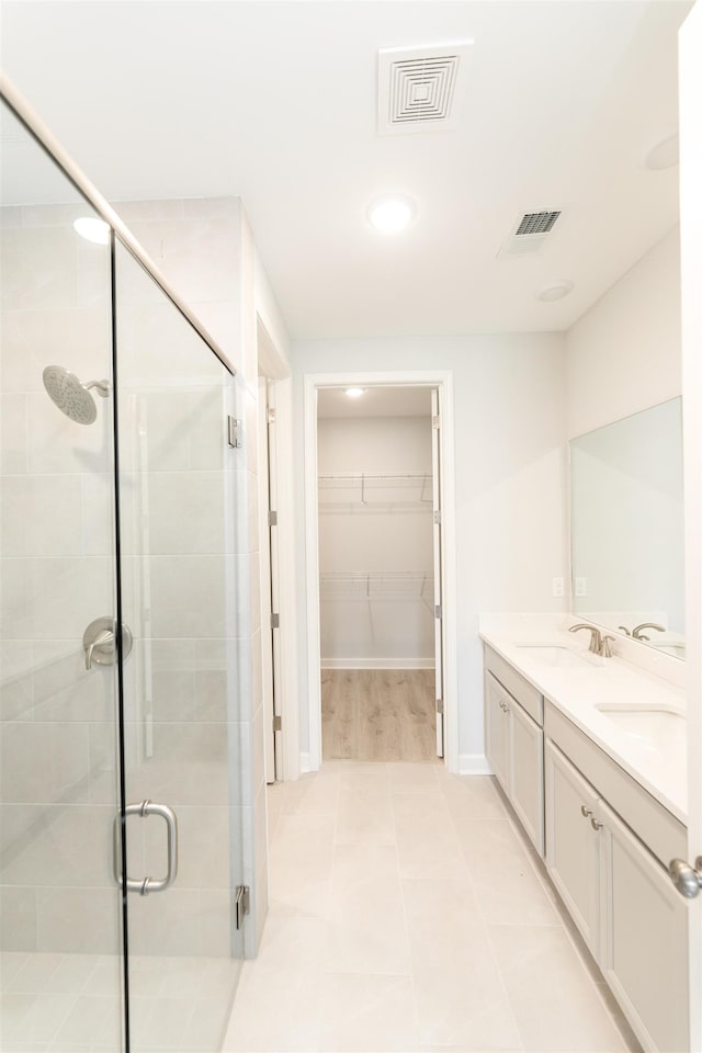 bathroom with an enclosed shower, vanity, and tile patterned floors