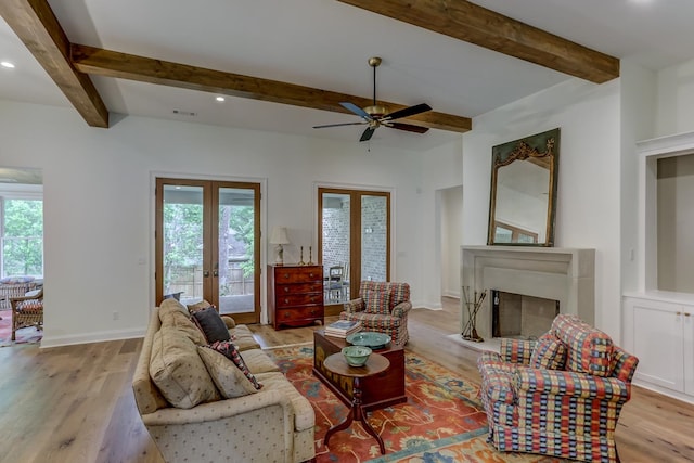 living room with ceiling fan, light hardwood / wood-style flooring, beamed ceiling, and french doors