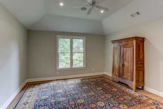 spare room with vaulted ceiling, ceiling fan, and light wood-type flooring