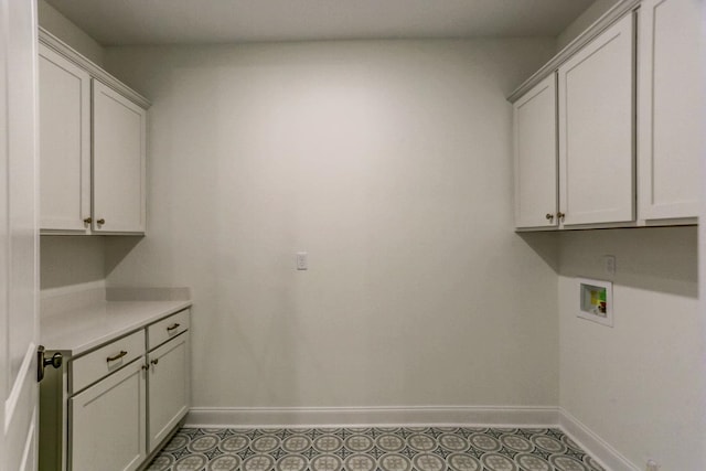 clothes washing area featuring washer hookup, dark tile floors, and cabinets