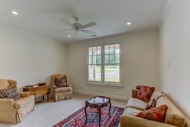 living room featuring light carpet, ornamental molding, and ceiling fan