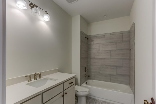 full bathroom with vanity, tiled shower / bath combo, tile floors, and toilet